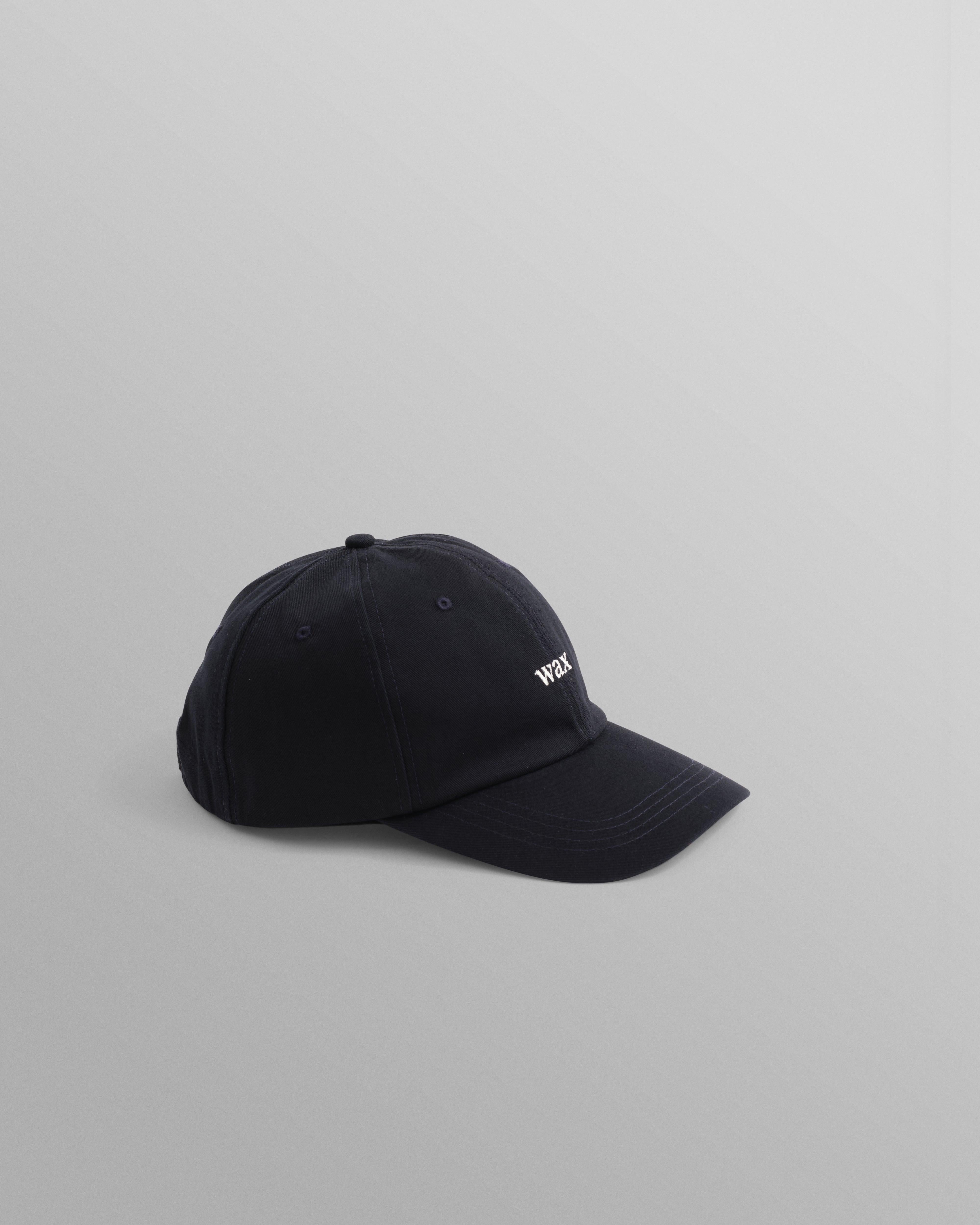Navy Spencer sport cap fra Wax London med bomuldsstof, afslappet stil og justerbar brem, vist på billedet.