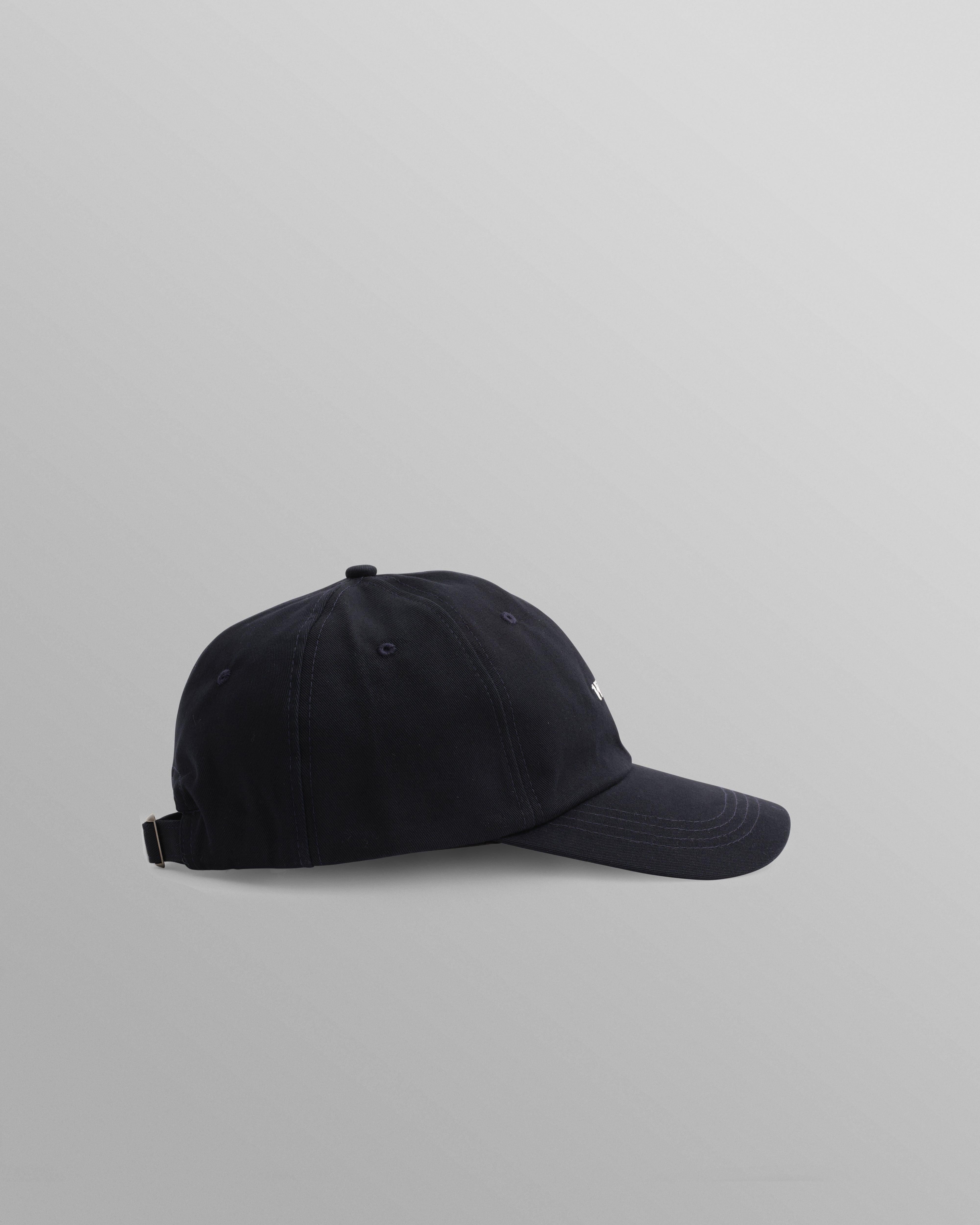 Mørkeblå Spencer sportskasket af bomuld fra Wax London, afslappet og sporty hovedbeklædning med justerbar pasform.