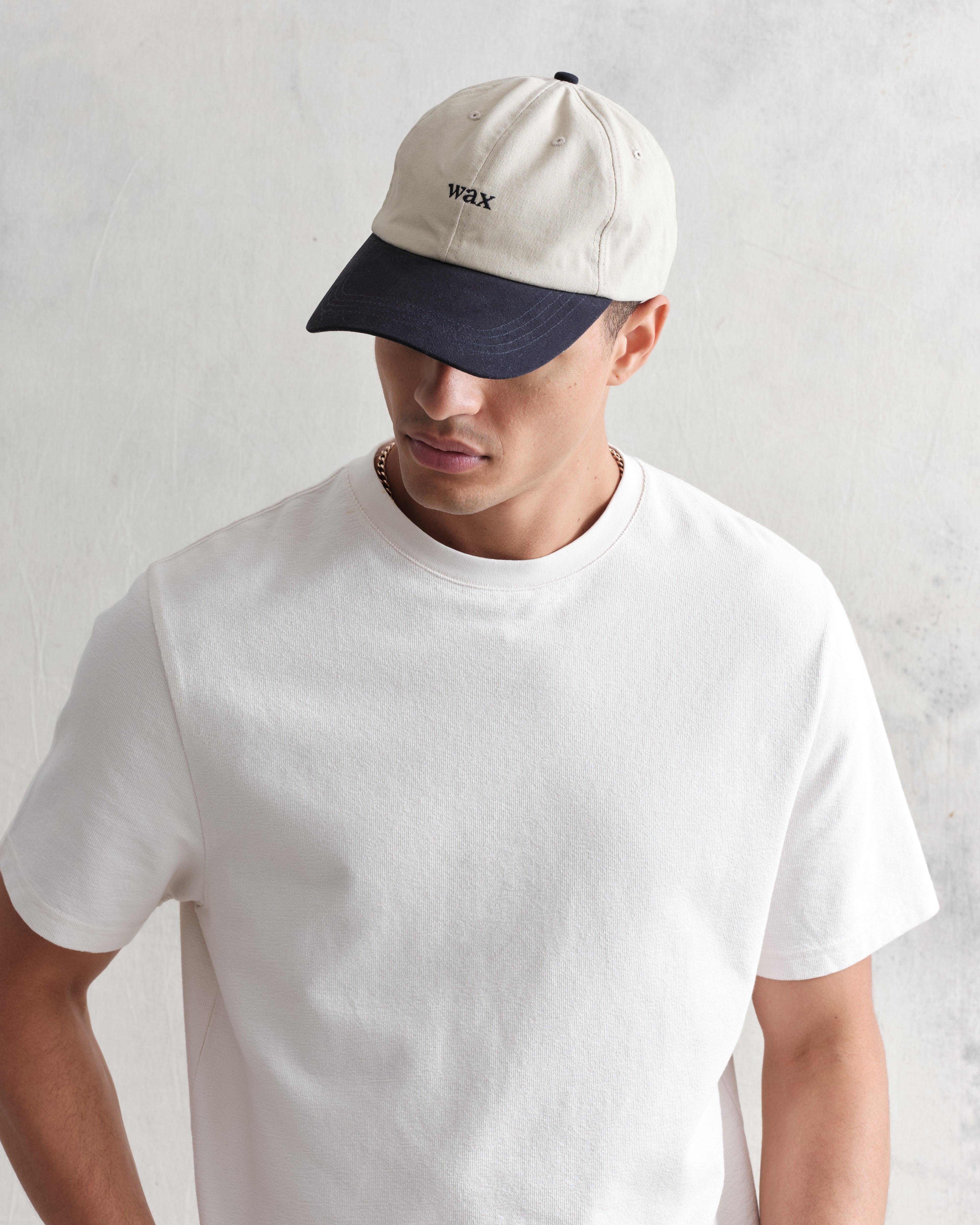 Mænds navy og stenfarvet bomuldssports cap fra Wax London med justerbar rem og komfortabel pasform.