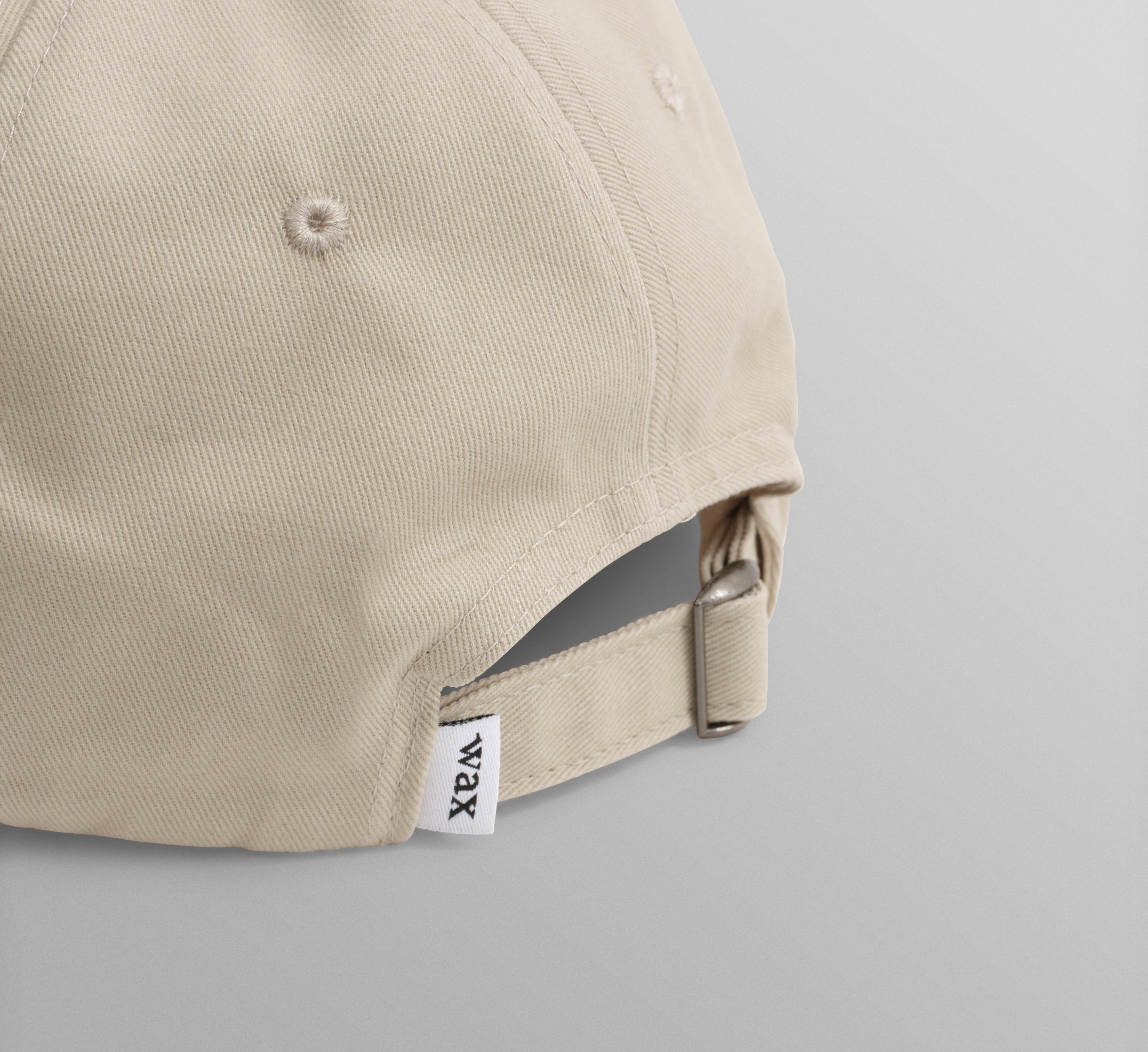 Sports cap fra Wax London i sten og navy med bomuldsstof, afslappet og sporty design.